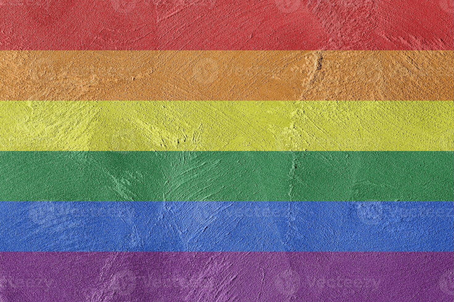 Rainbow LGBTQ or gay pride flag on decorative plaster or concrete texture. Abstract background. photo