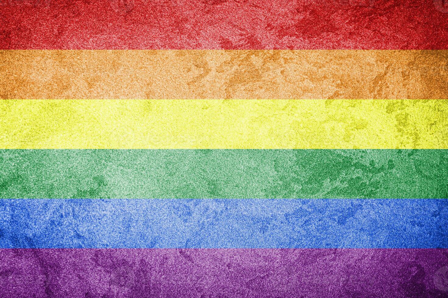 Rainbow LGBTQ or gay pride flag on decorative plaster or concrete texture. Abstract background. photo