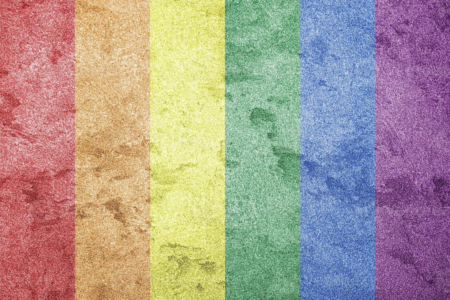 Rainbow LGBTQ or gay pride flag on decorative plaster or concrete texture. Abstract background. photo