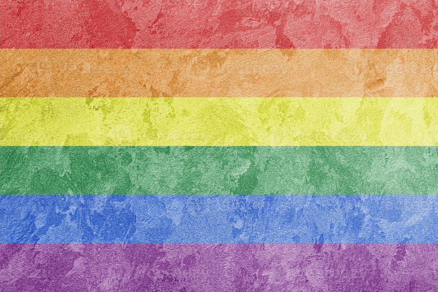Rainbow LGBTQ or gay pride flag on decorative plaster or concrete texture. Abstract background. photo
