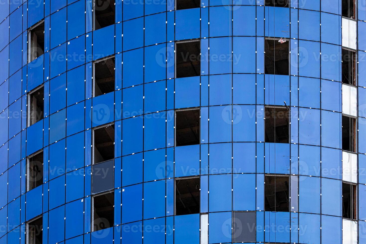 Fragment of an unfinished building under construction with blue cladding panels. photo