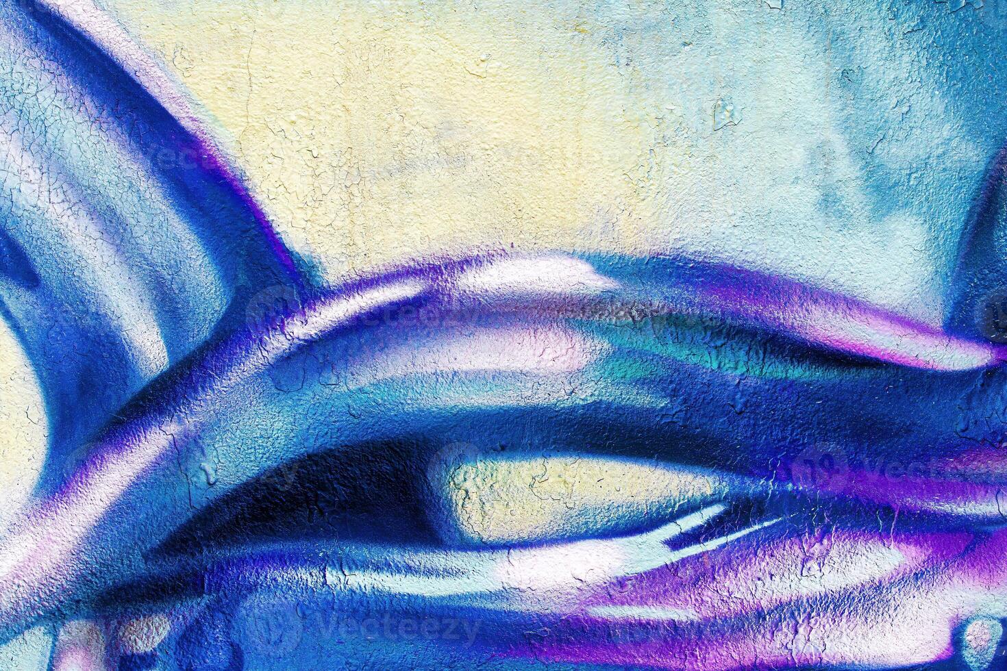 A fragment of colorful graffiti painted on a wall. Abstract urban background. photo