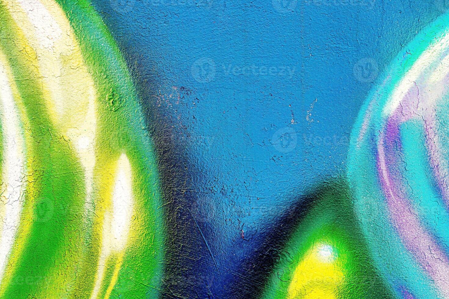A fragment of colorful graffiti painted on a wall. Abstract urban background. photo
