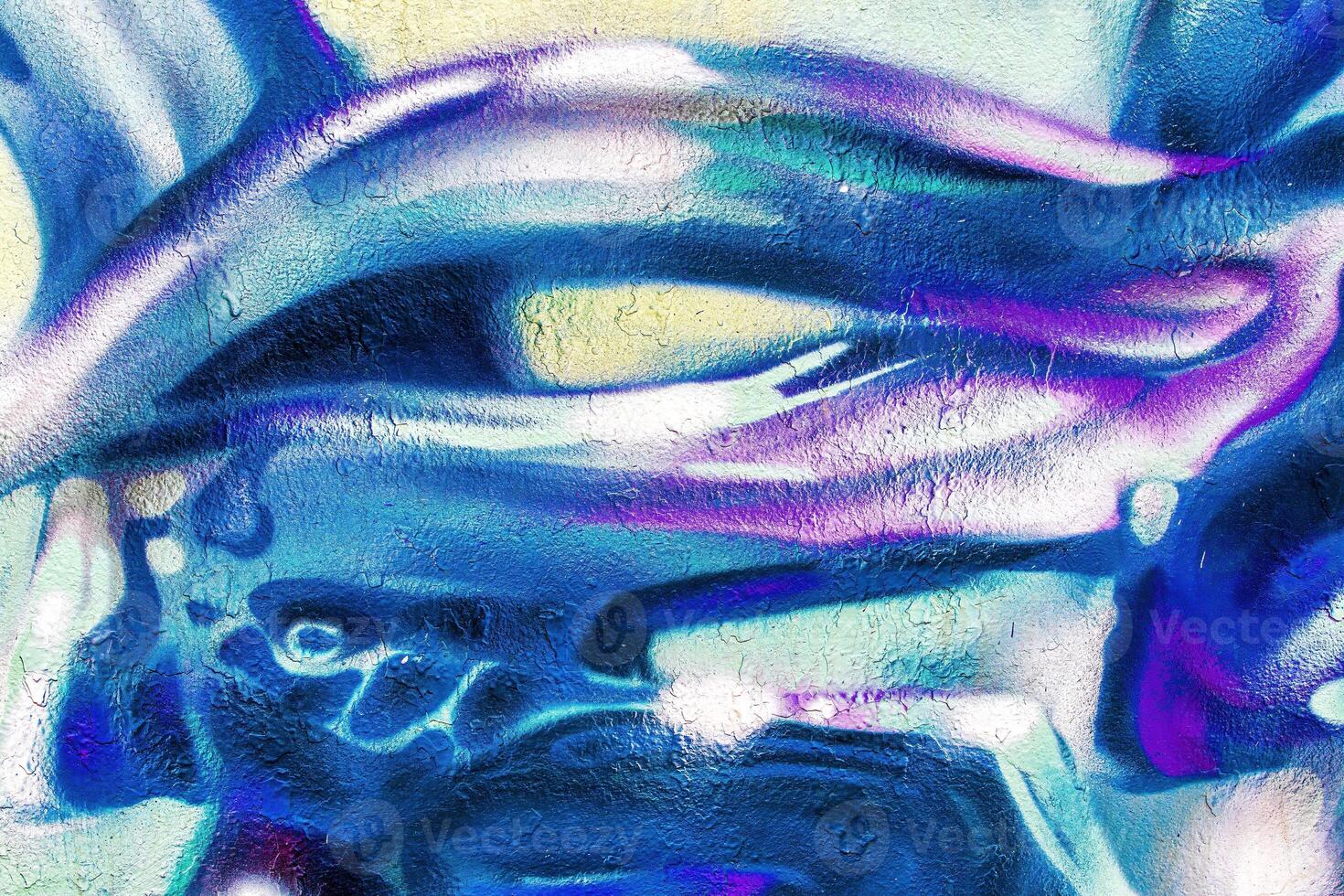 A fragment of colorful graffiti painted on a wall. Abstract urban background. photo