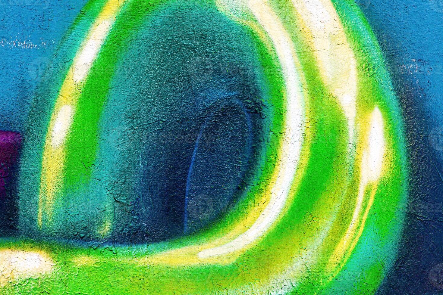 A fragment of colorful graffiti painted on a wall. Abstract urban background. photo