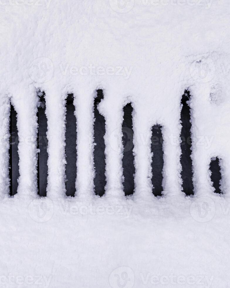 Snow covered metal sewer grate. Winter weather concept. photo