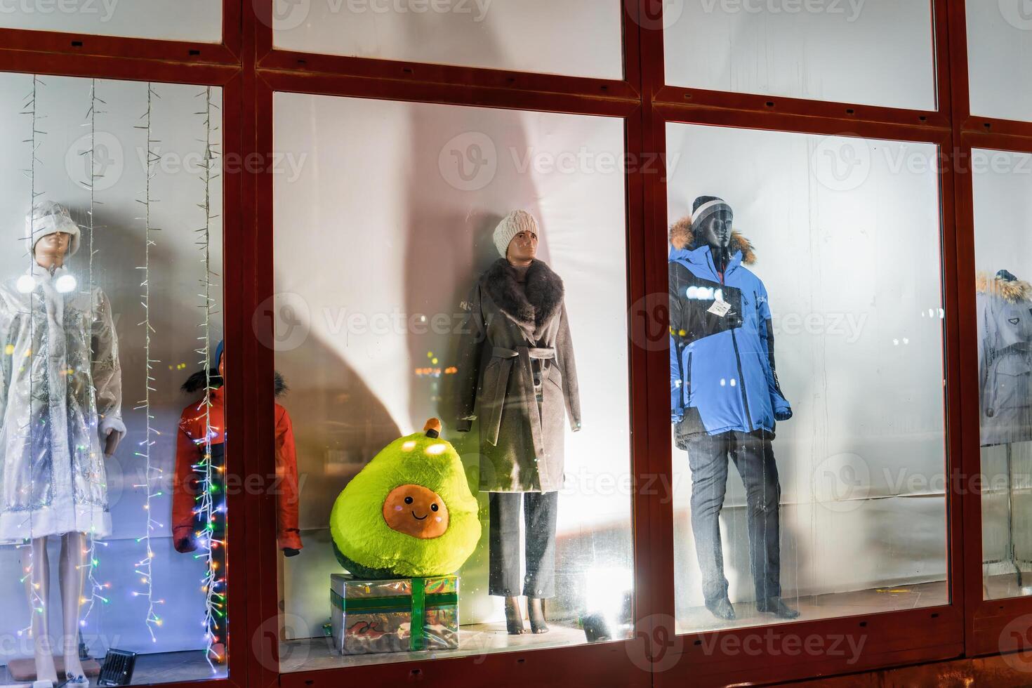 Russia, Kaluga - DECEMBER 27, 2021 Male and female mannequins in a shop window at night, illuminated by lamps. photo