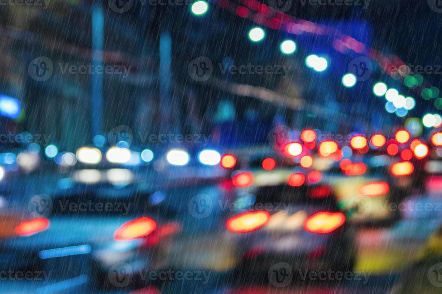 Blurry lights of moving cars and lanterns reflecting on the wet asphalt in the night city in rain. photo