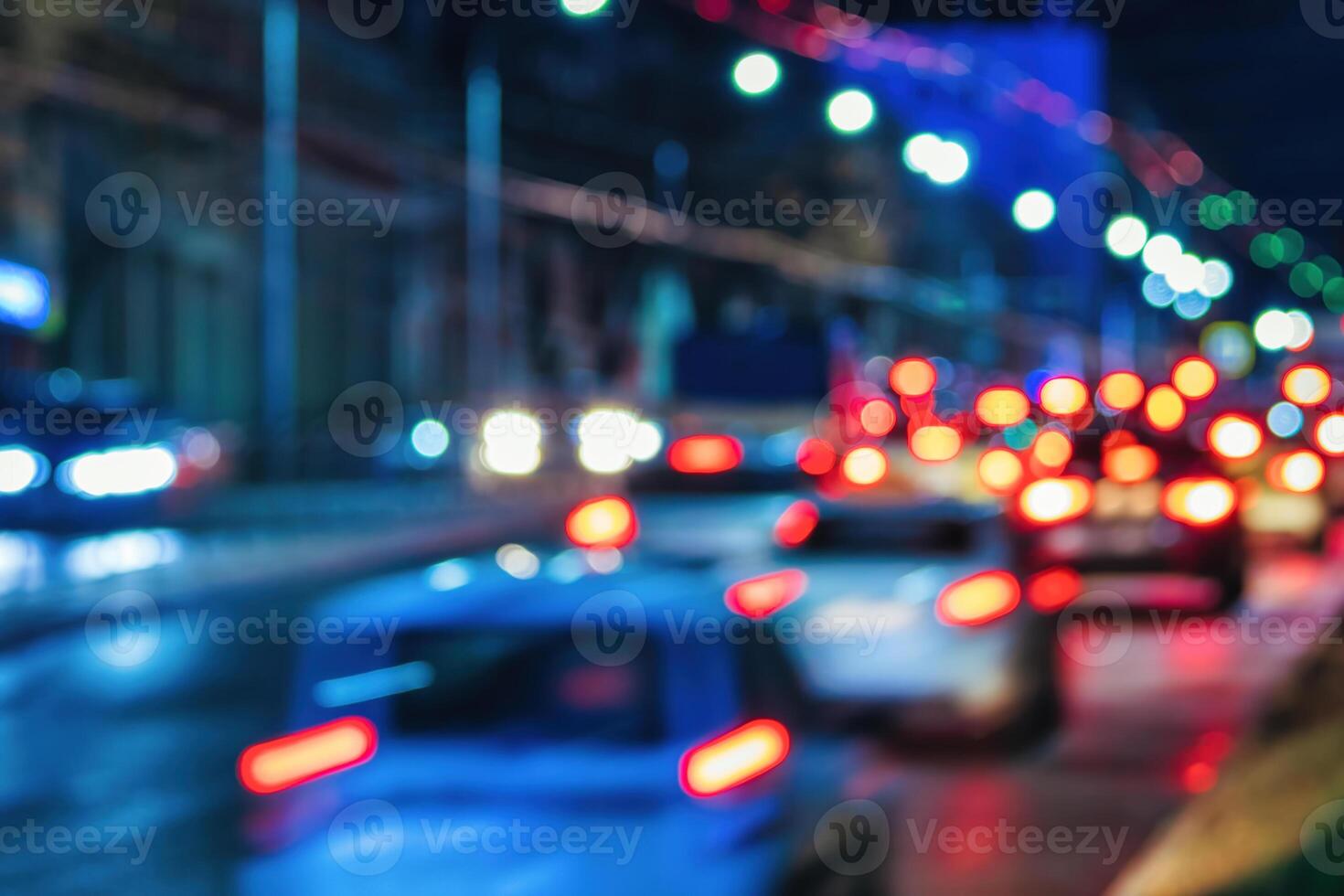 Blurry lights of moving cars and lanterns reflecting on the wet asphalt in the night city. photo