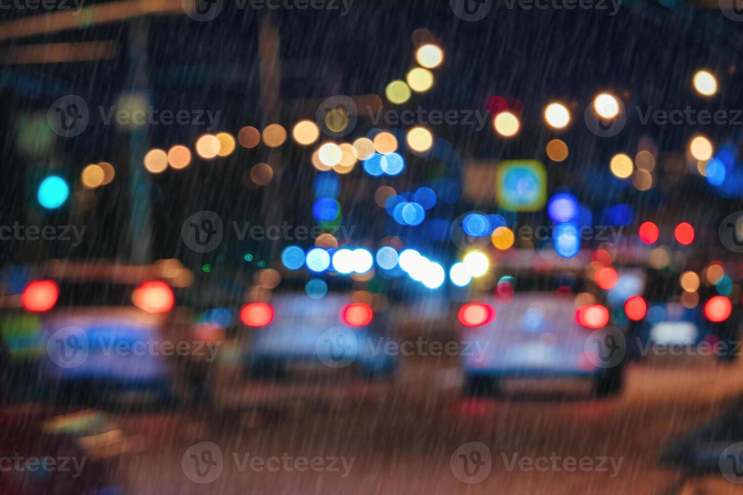 Blurry lights of moving cars and lanterns reflecting on the wet asphalt in the night city in rain. photo
