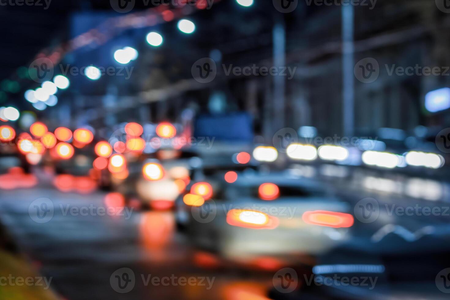 Blurry lights of moving cars and lanterns reflecting on the wet asphalt in the night city. photo