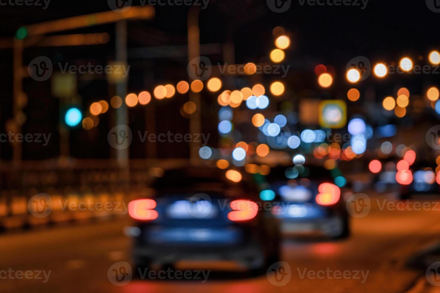 Blurry lights of moving cars and lanterns reflecting on the wet asphalt in the night city. photo