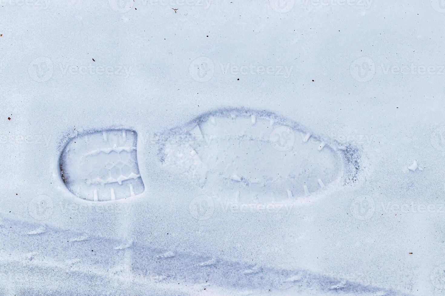 Boot track on thin first snow in winter. photo