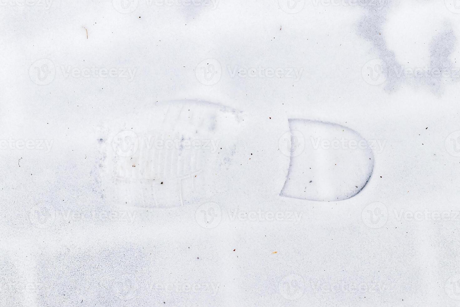 Boot track on thin first snow in winter. photo