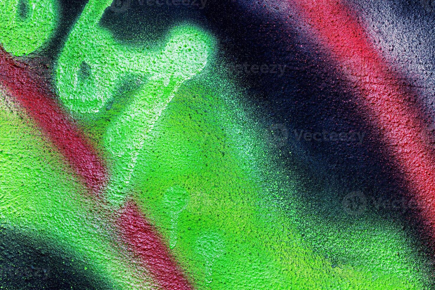 A fragment of colorful graffiti painted on a wall. Abstract urban background. photo