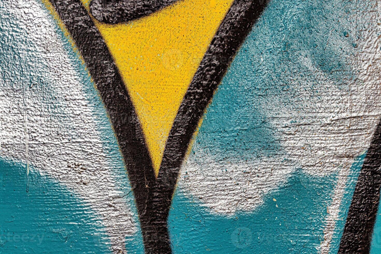 A fragment of colorful graffiti painted on a wall. Abstract urban background. photo