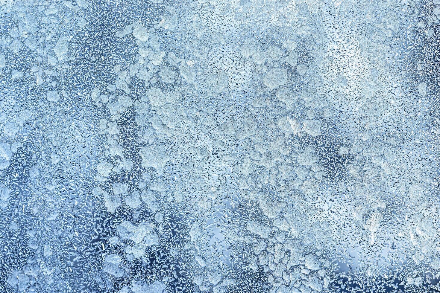 The texture of the glass covered with frost in winter in cold weather. Abstract background. photo