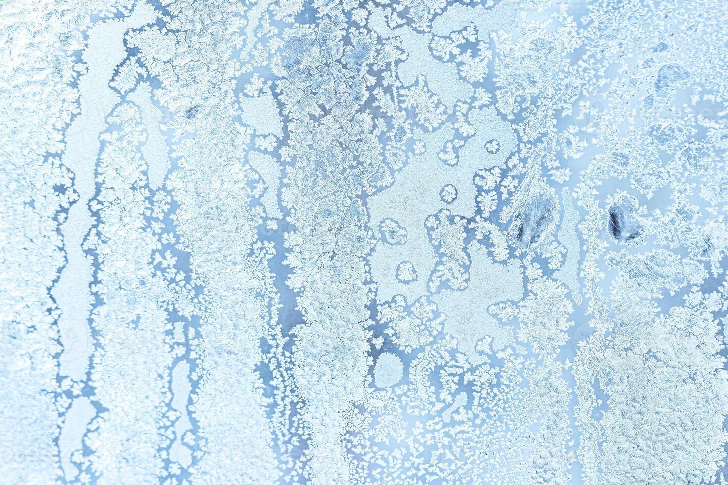 The texture of the glass covered with frost in winter in cold weather. Abstract background. photo