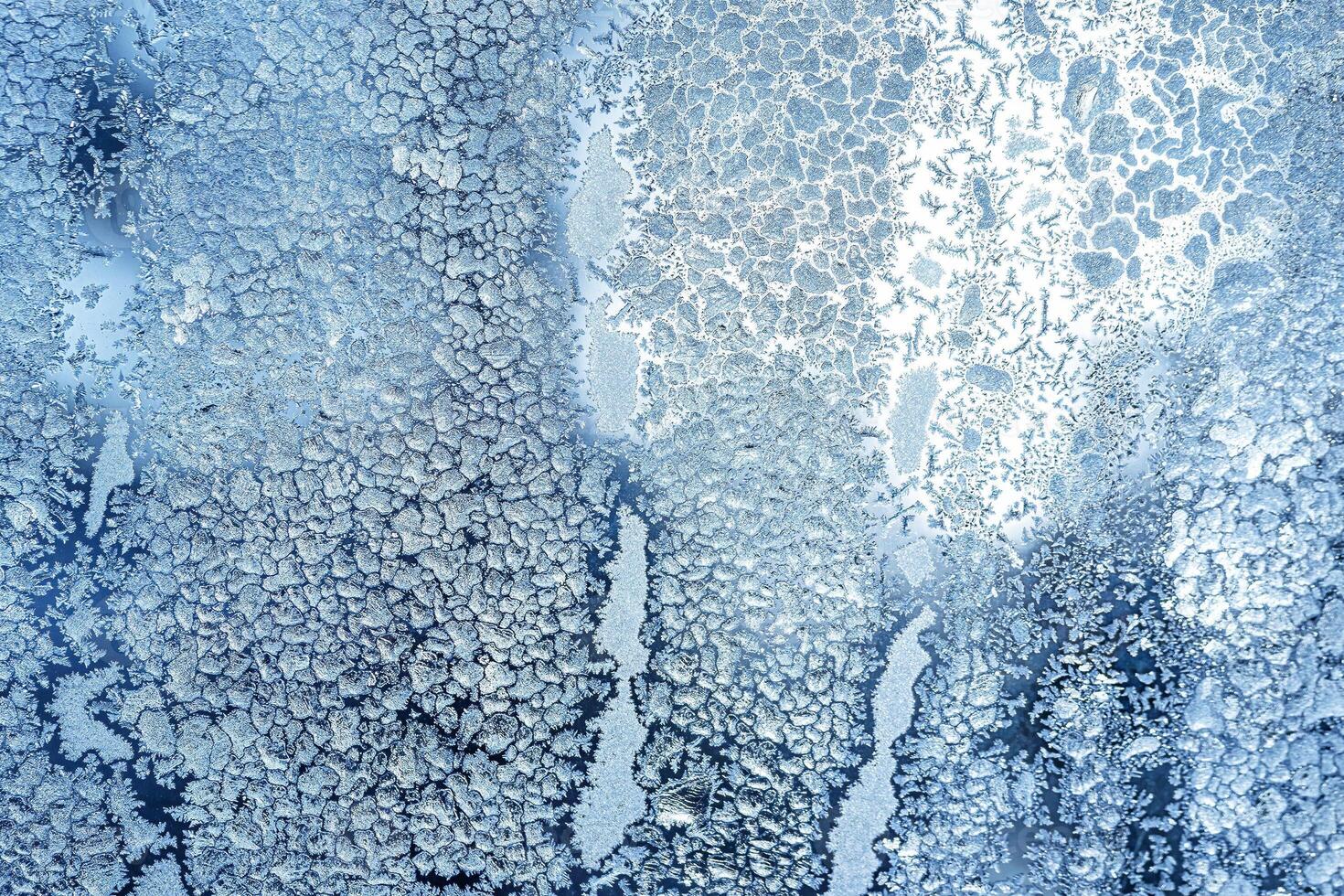 The texture of the glass covered with frost in winter in cold weather. Abstract background. photo