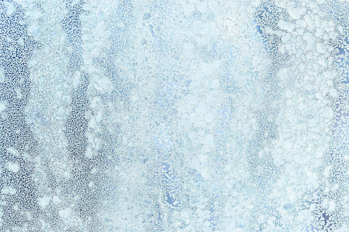 The texture of the glass covered with frost in winter in cold weather. Abstract background. photo
