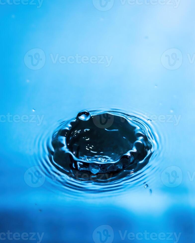 A drop of water and splashes with blurry waves. photo