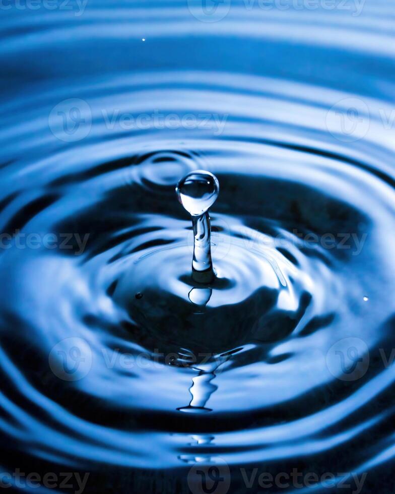 A drop of water and splashes with blurry waves. photo