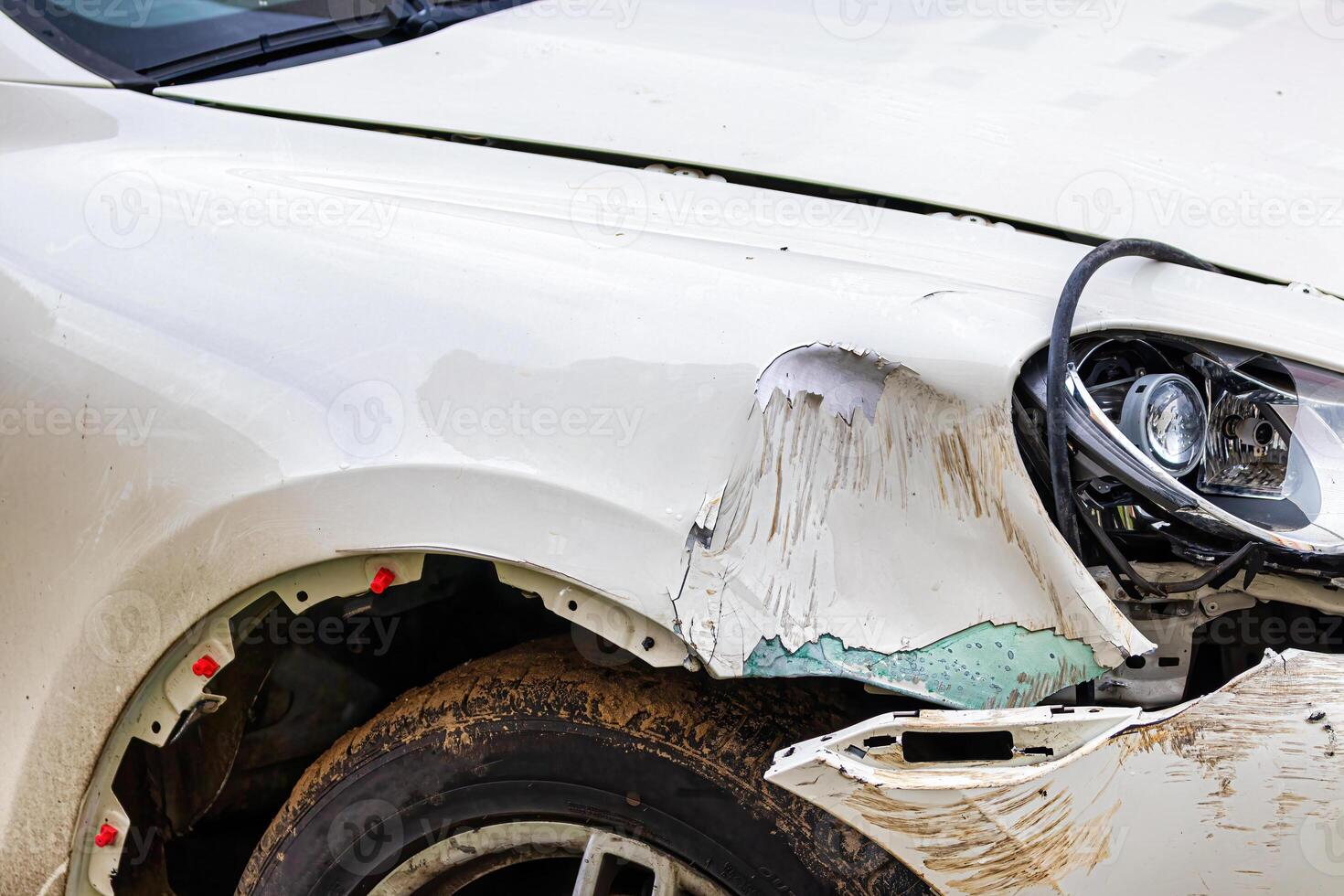Broken car after a crash. Damaged wing and headlamp of a car, scratches on a car body. photo