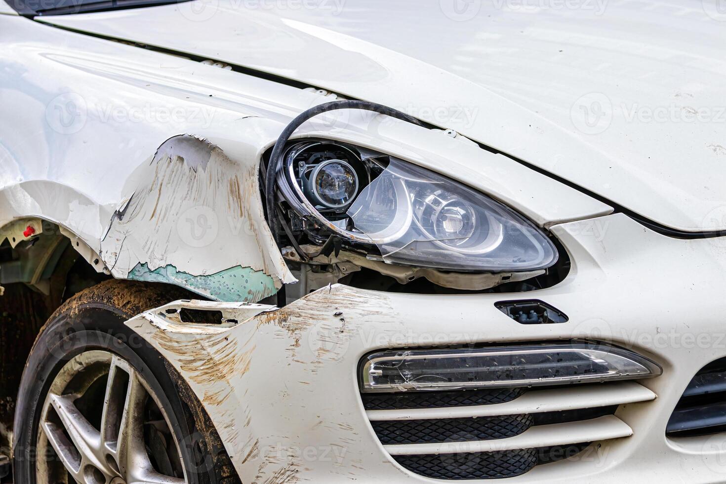 Broken car after a crash. Damaged wing and headlamp of a car, scratches on a car body. photo