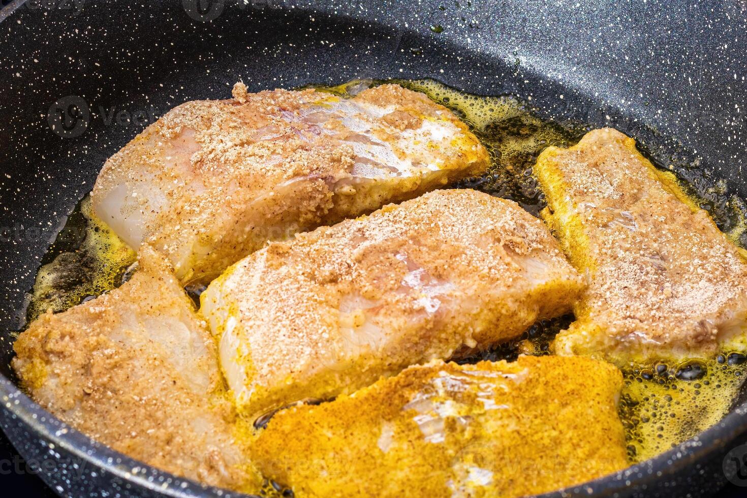 Breaded fish steaks, fried in a pan with vegetable oil. photo