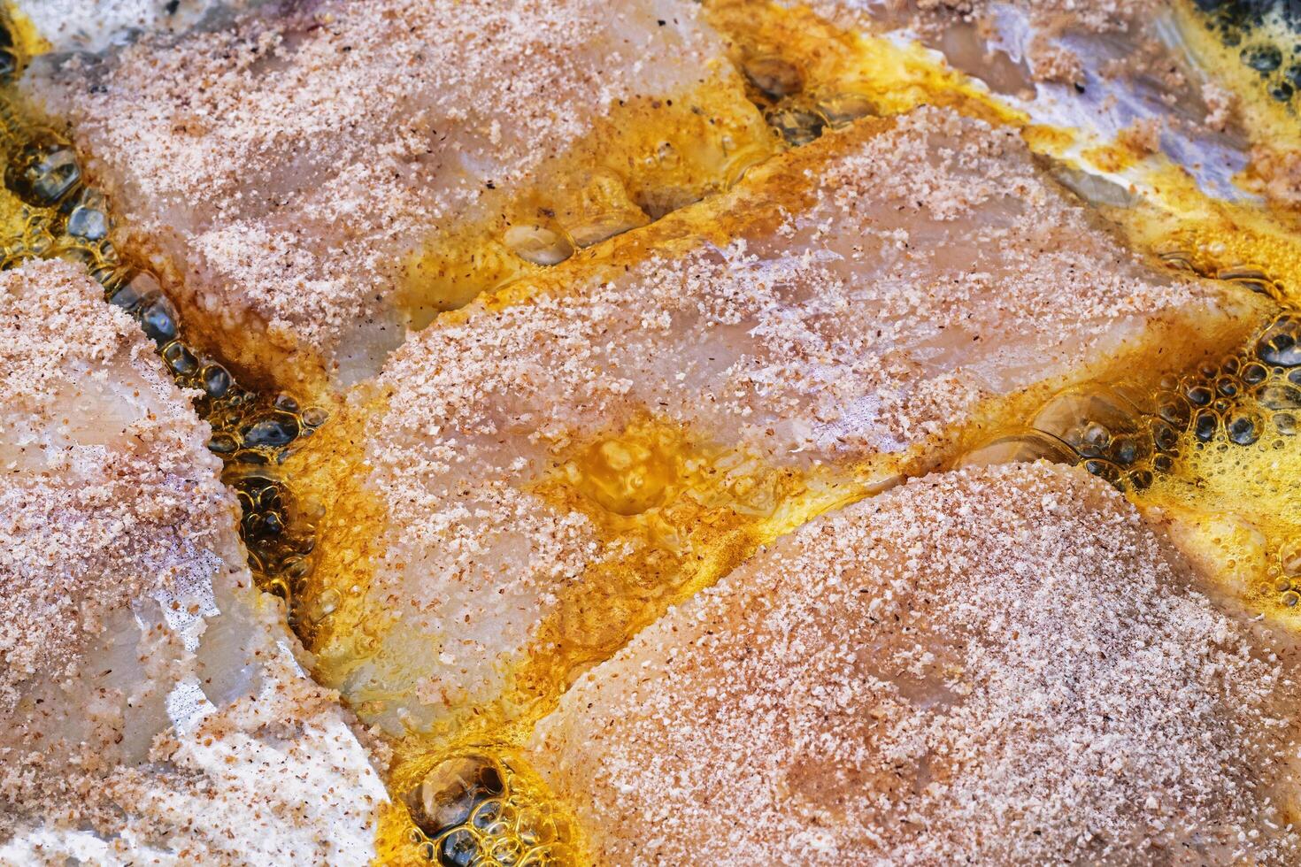 Breaded fish steaks, fried in a pan with vegetable oil. photo