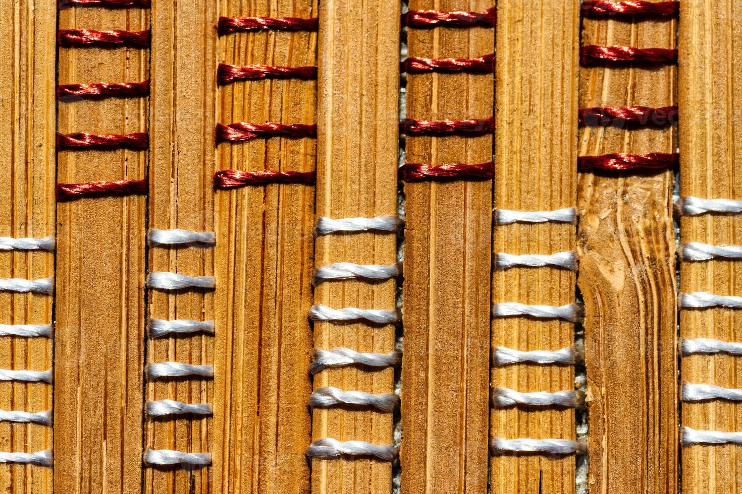 A background of bamboo stems intertwined with threads. photo