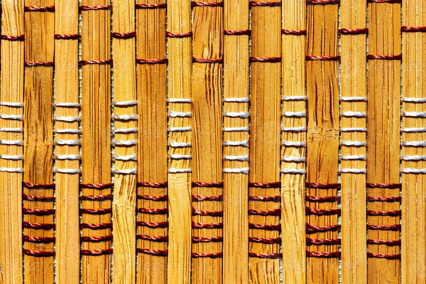 A background of bamboo stems intertwined with threads. photo