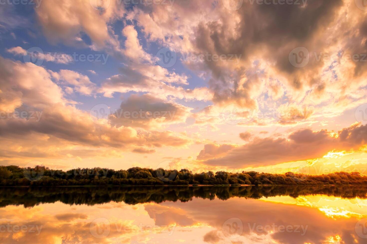 Sunset on the river at summer evening with clouds and trees. Water reflection of a sky. photo
