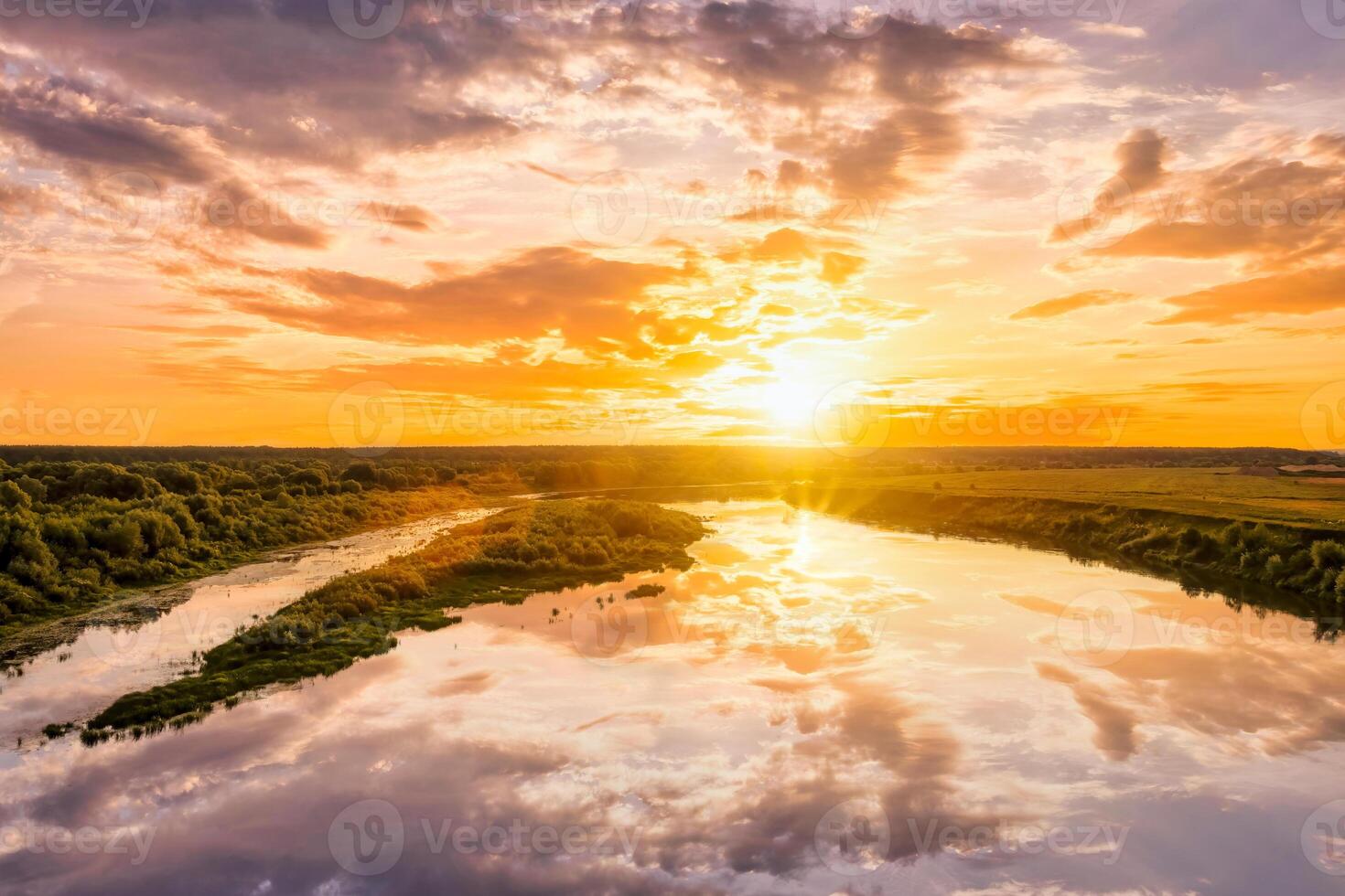 Aerial view to sunset on the river at summer evening with clouds and trees. Water reflection of a sky. photo