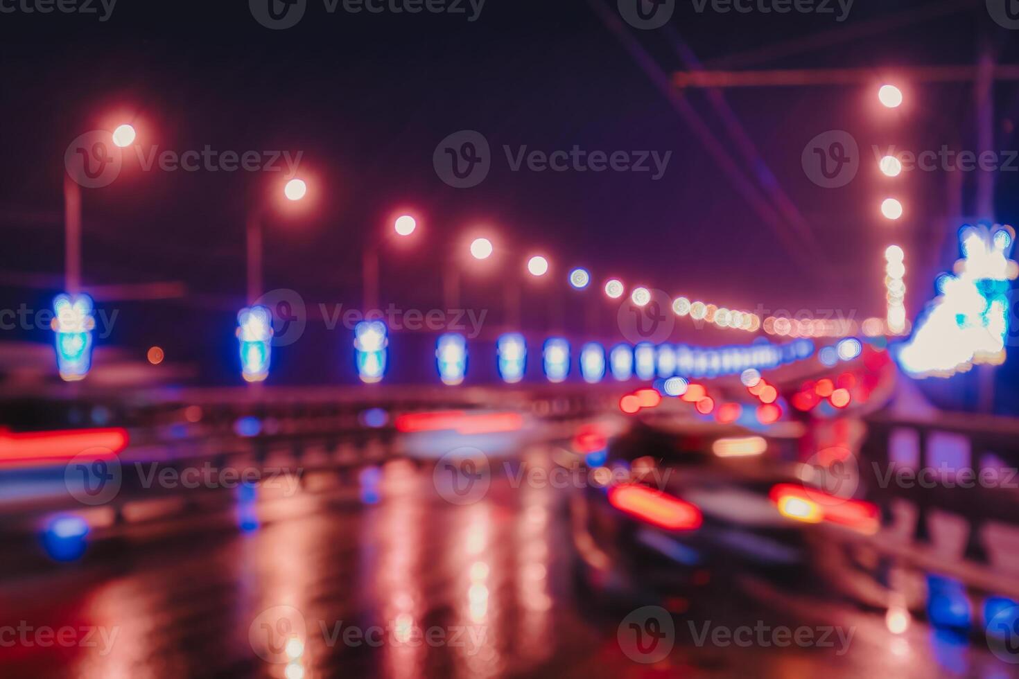 Blurry lights of moving cars and lanterns reflecting on the wet asphalt in the night city. photo