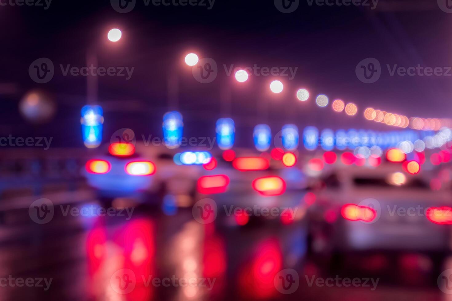 Blurry lights of moving cars and lanterns reflecting on the wet asphalt in the night city. photo