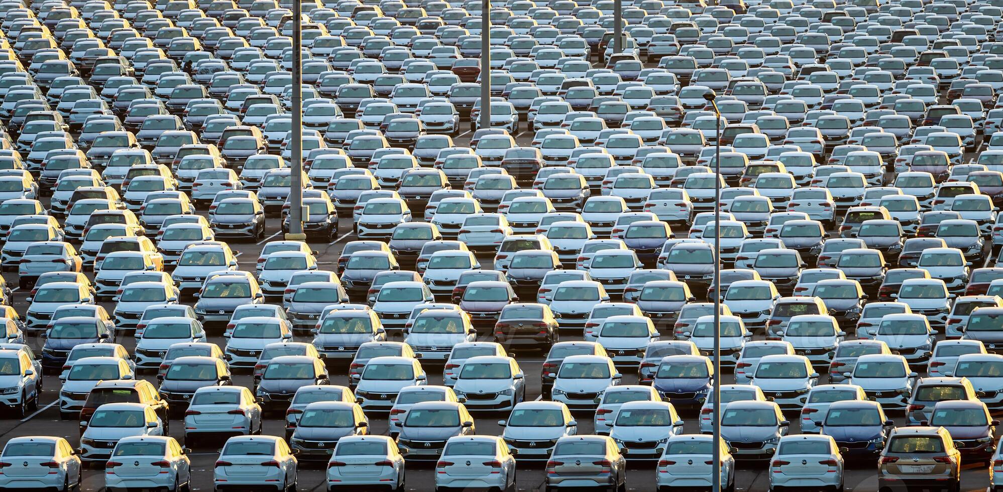 Volkswagen Group Rus, Russia, Kaluga - MAY 25, 2020 Rows of a new cars parked in a distribution center on a sunny morning in the autumn. photo