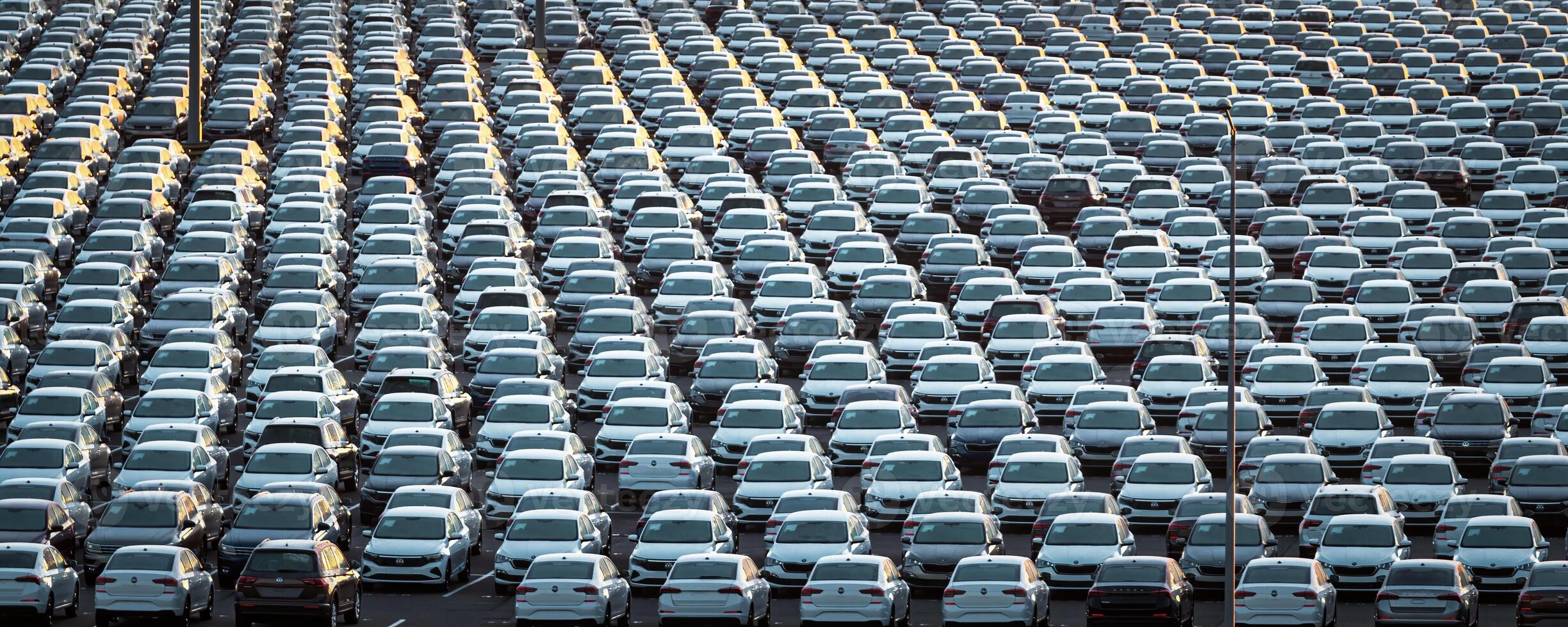 Volkswagen Group Rus, Russia, Kaluga - MAY 25, 2020 Rows of a new cars parked in a distribution center on a sunny morning in the autumn. photo