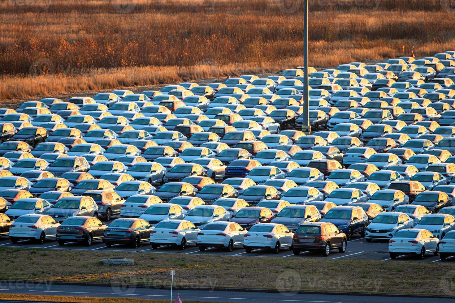 Volkswagen Group Rus, Russia, Kaluga - MAY 25, 2020 Rows of a new cars parked in a distribution center on a sunny morning in the autumn. photo
