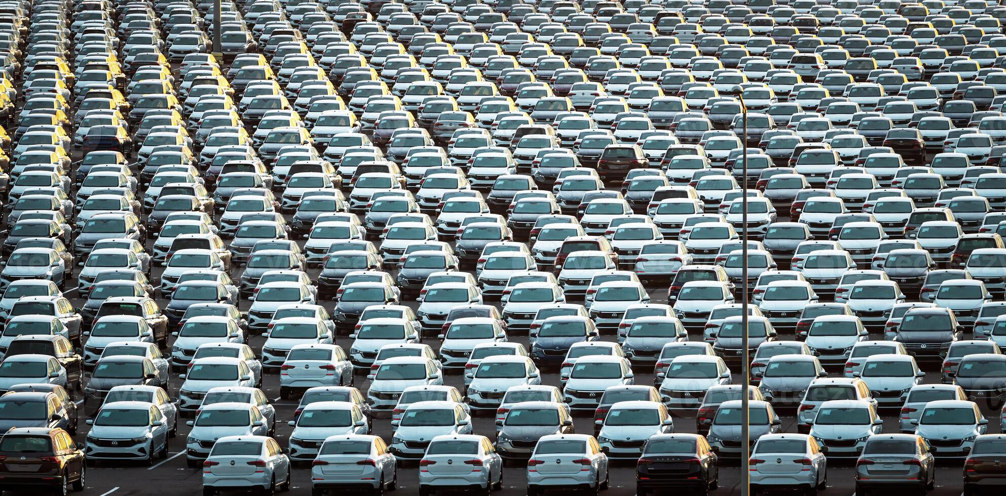 Volkswagen Group Rus, Russia, Kaluga - MAY 25, 2020 Rows of a new cars parked in a distribution center on a sunny morning in the autumn. photo