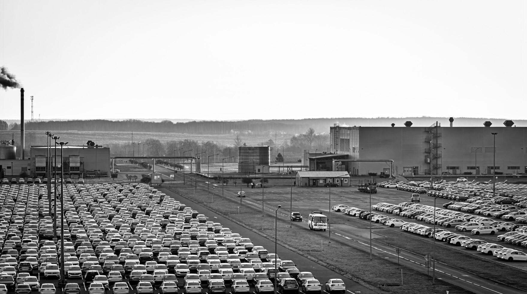 Volkswagen Group Rus, Russia, Kaluga - NOVEMBER 17, 2020 Rows of a new cars parked in a distribution center and a car factory buildings. photo