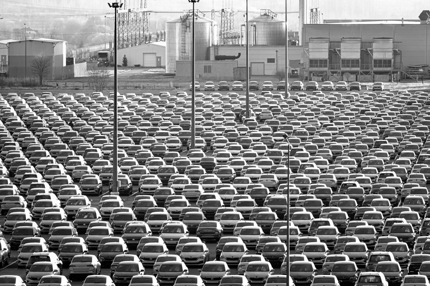 Volkswagen Group Rus, Russia, Kaluga - NOVEMBER 17, 2020 Rows of a new cars parked in a distribution center and a car factory buildings. photo