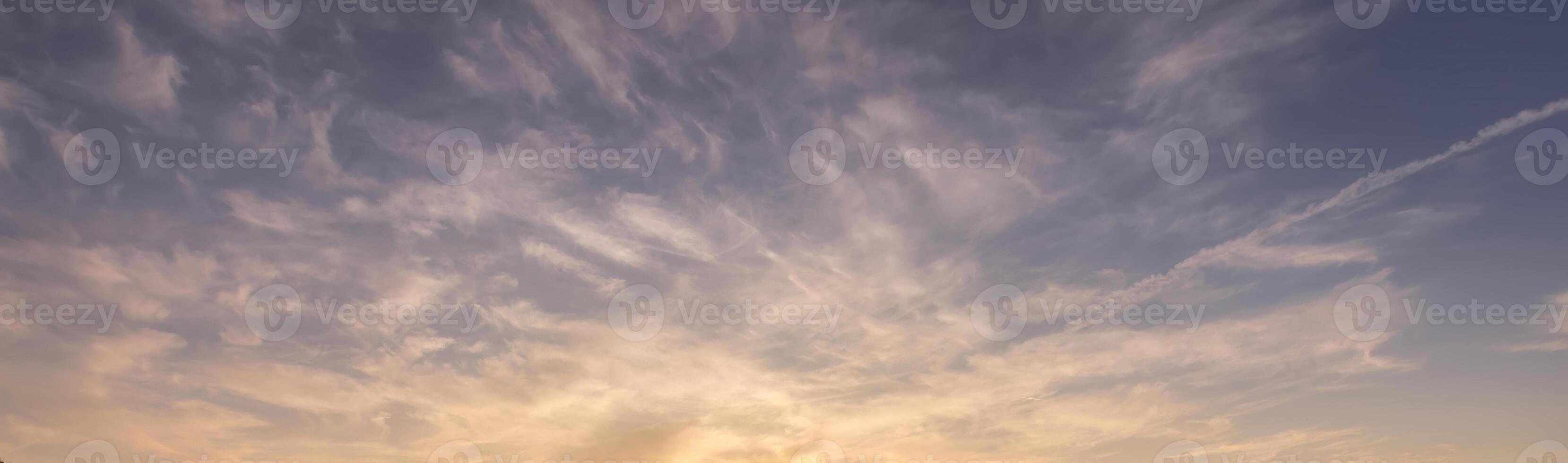 Colorful dramatic clouds lit by a sun against the sunset or sunrise sky. photo