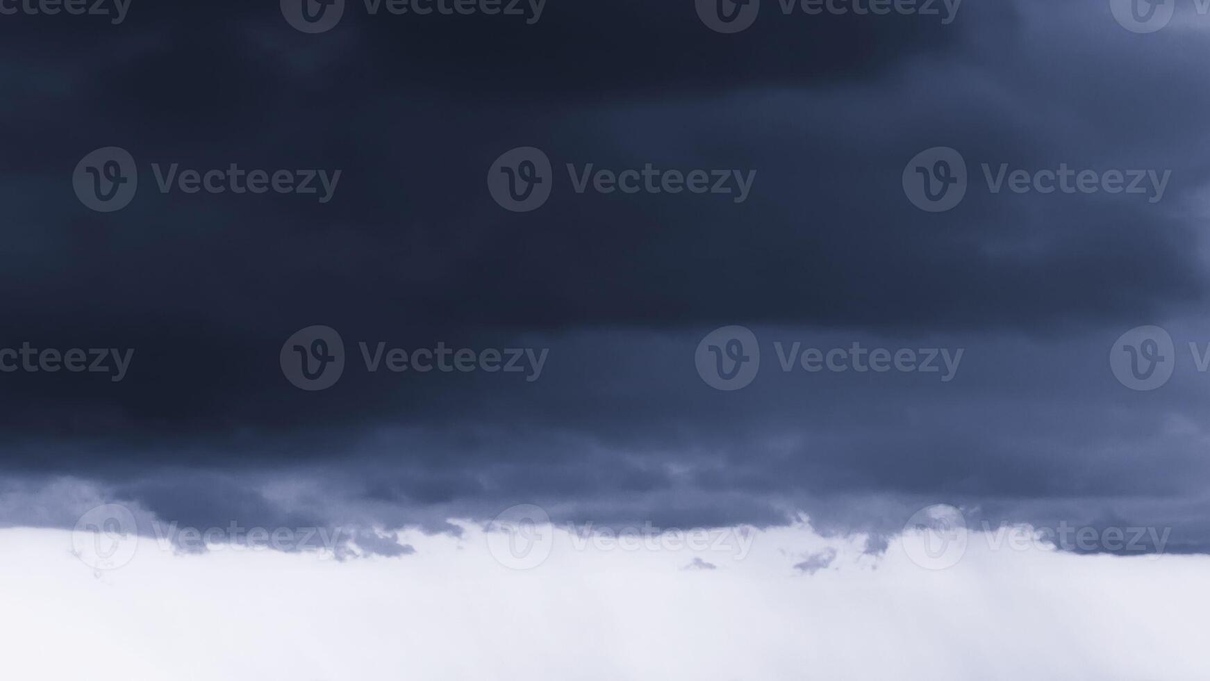 Dark monochrome heavy storm clouds before a thunderstorm or hurricane. Dramatic clouds in overcast weather. photo