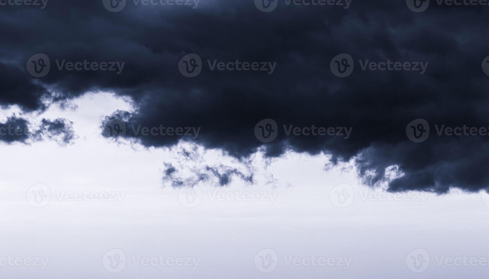 Dark monochrome heavy storm clouds before a thunderstorm or hurricane. Dramatic clouds in overcast weather. photo
