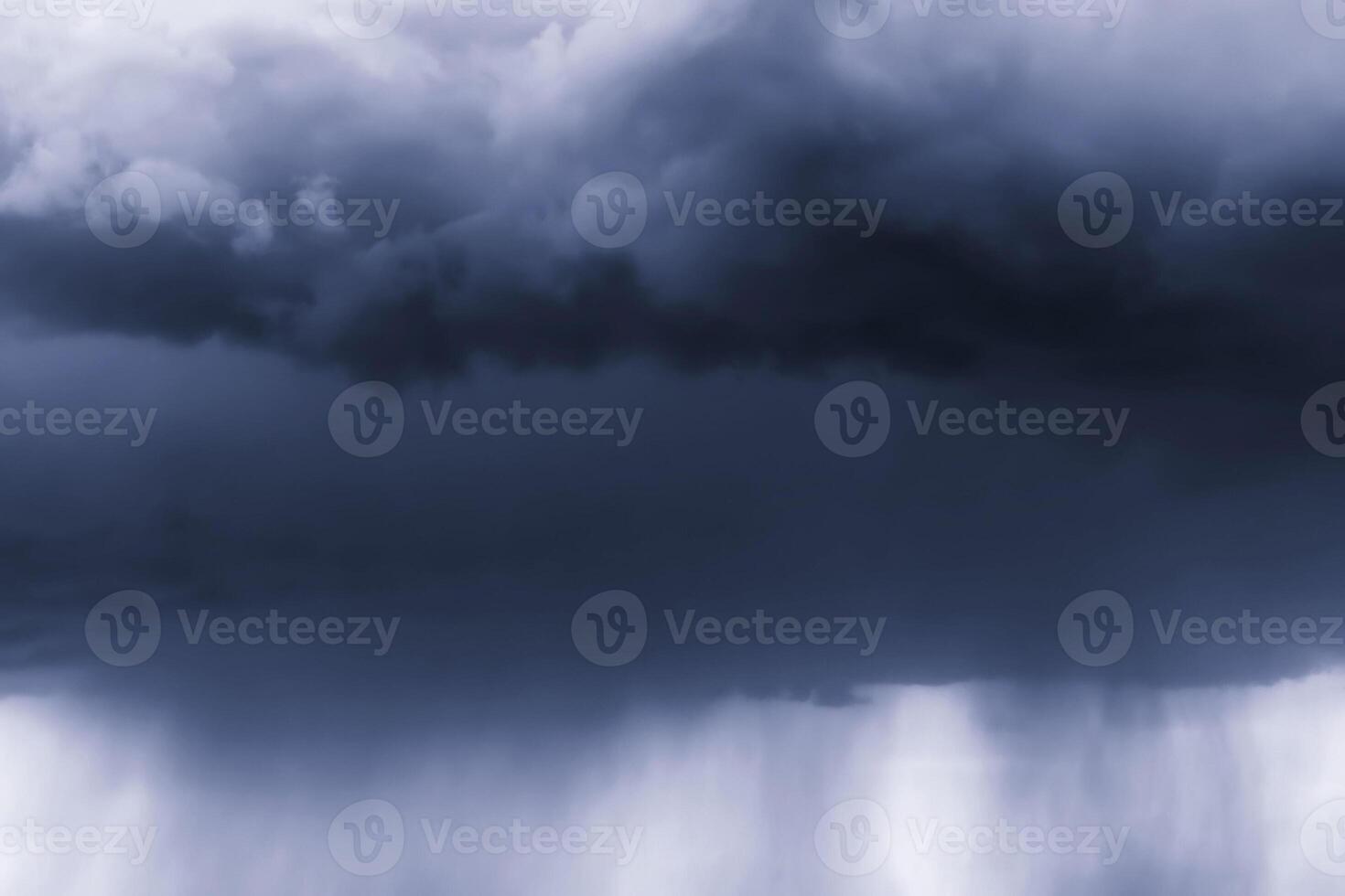 Dark monochrome heavy storm clouds before a thunderstorm or hurricane. Dramatic clouds in overcast weather. photo