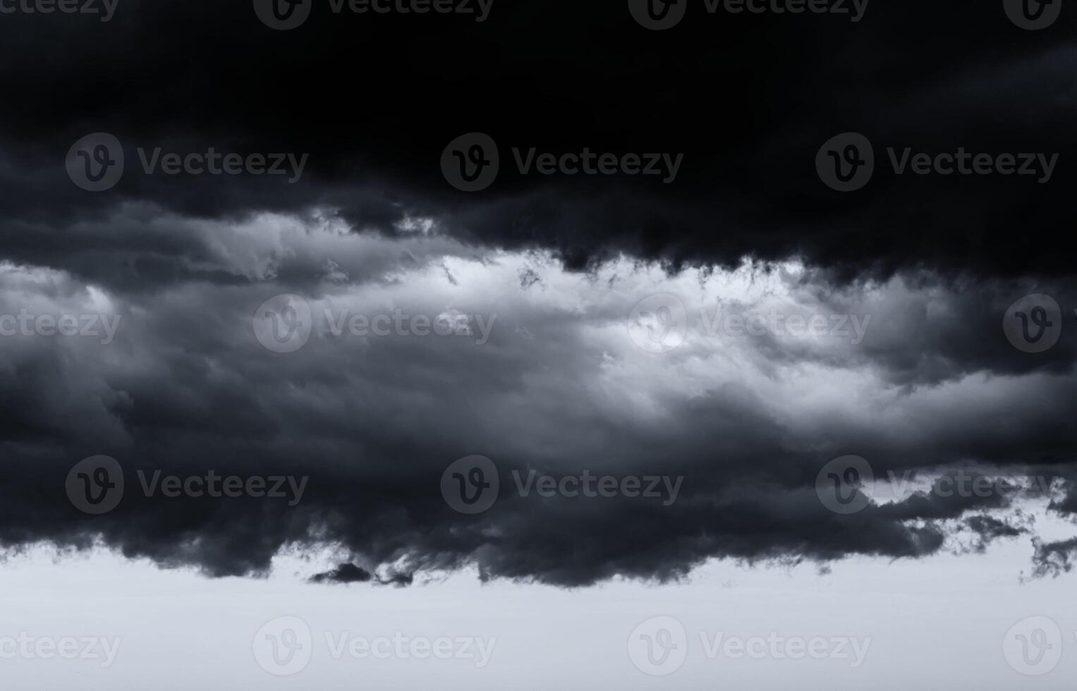 Dark monochrome heavy storm clouds before a thunderstorm or hurricane. Dramatic clouds in overcast weather. photo