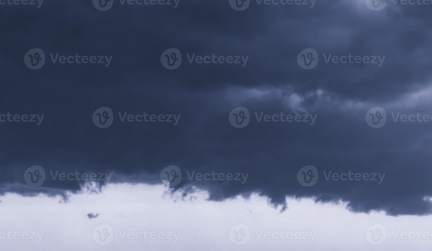 Dark monochrome heavy storm clouds before a thunderstorm or hurricane. Dramatic clouds in overcast weather. photo