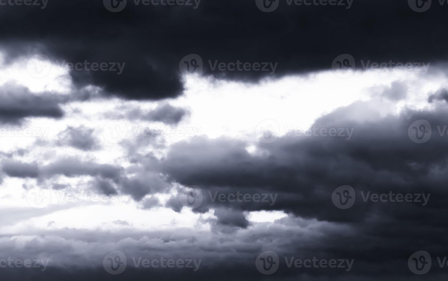 Dark monochrome heavy storm clouds before a thunderstorm or hurricane. Dramatic clouds in overcast weather. photo