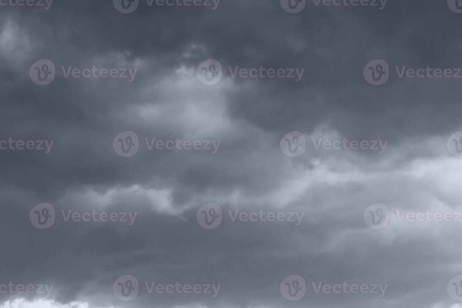Dark monochrome heavy storm clouds before a thunderstorm or hurricane. Dramatic clouds in overcast weather. photo